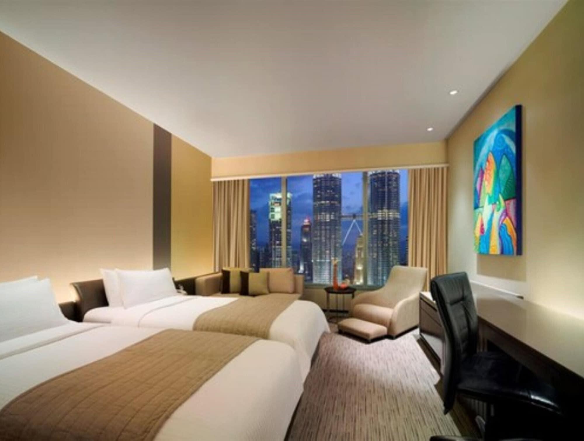 Traders Hotel, קואלה לומפור מראה חיצוני תמונה The photo shows a modern hotel room with two twin beds placed side by side, featuring simple, elegant bedding. There's a large window that offers a view of a city skyline, indicating it's likely located in an urban area. The room has a neutral color 