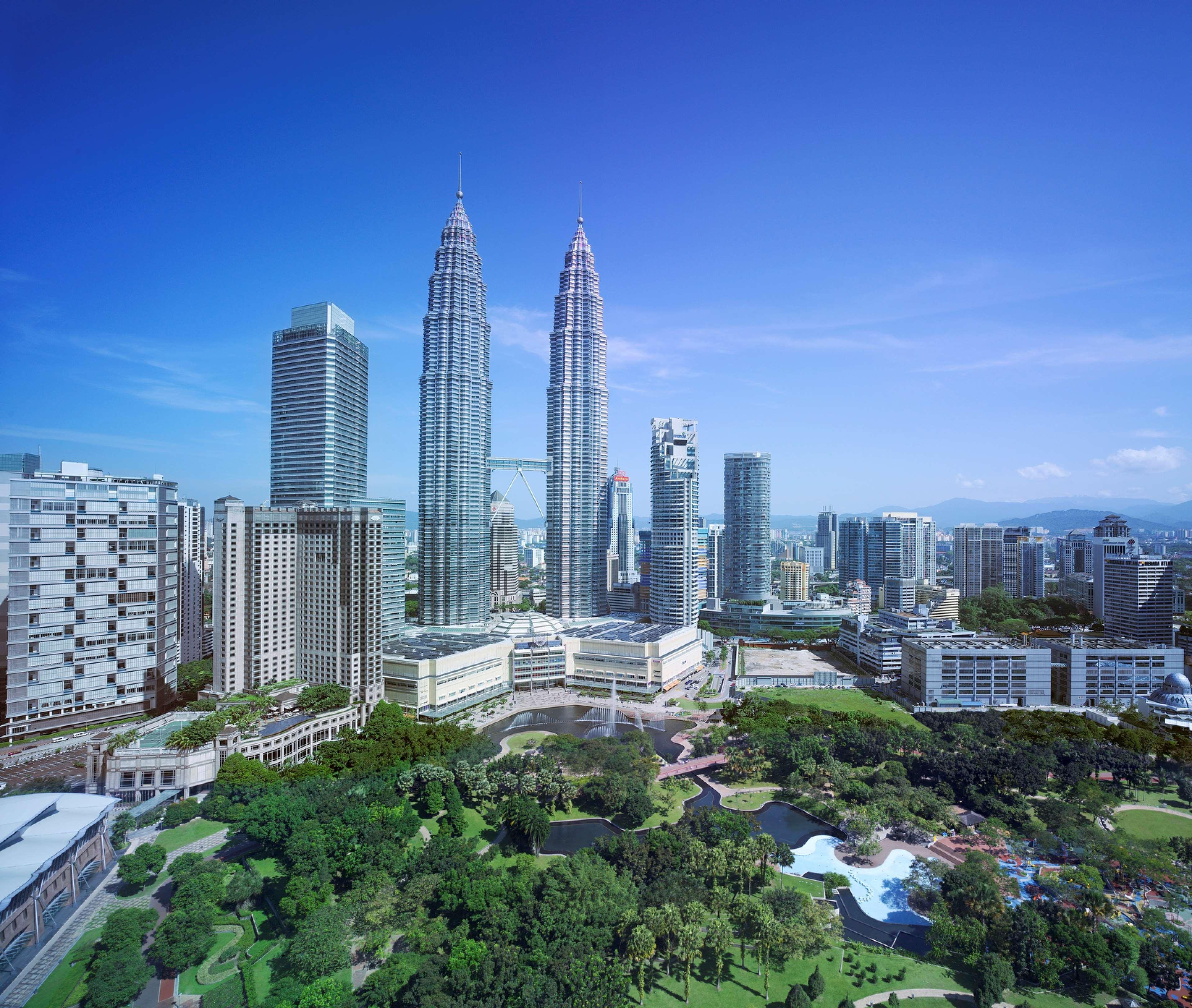 Traders Hotel, קואלה לומפור מראה חיצוני תמונה The photo shows a modern urban skyline featuring prominent skyscrapers, including the iconic Petronas Twin Towers, which are among the tallest buildings in the world. The surrounding area includes a mix of contemporary buildings and greenery, hinting