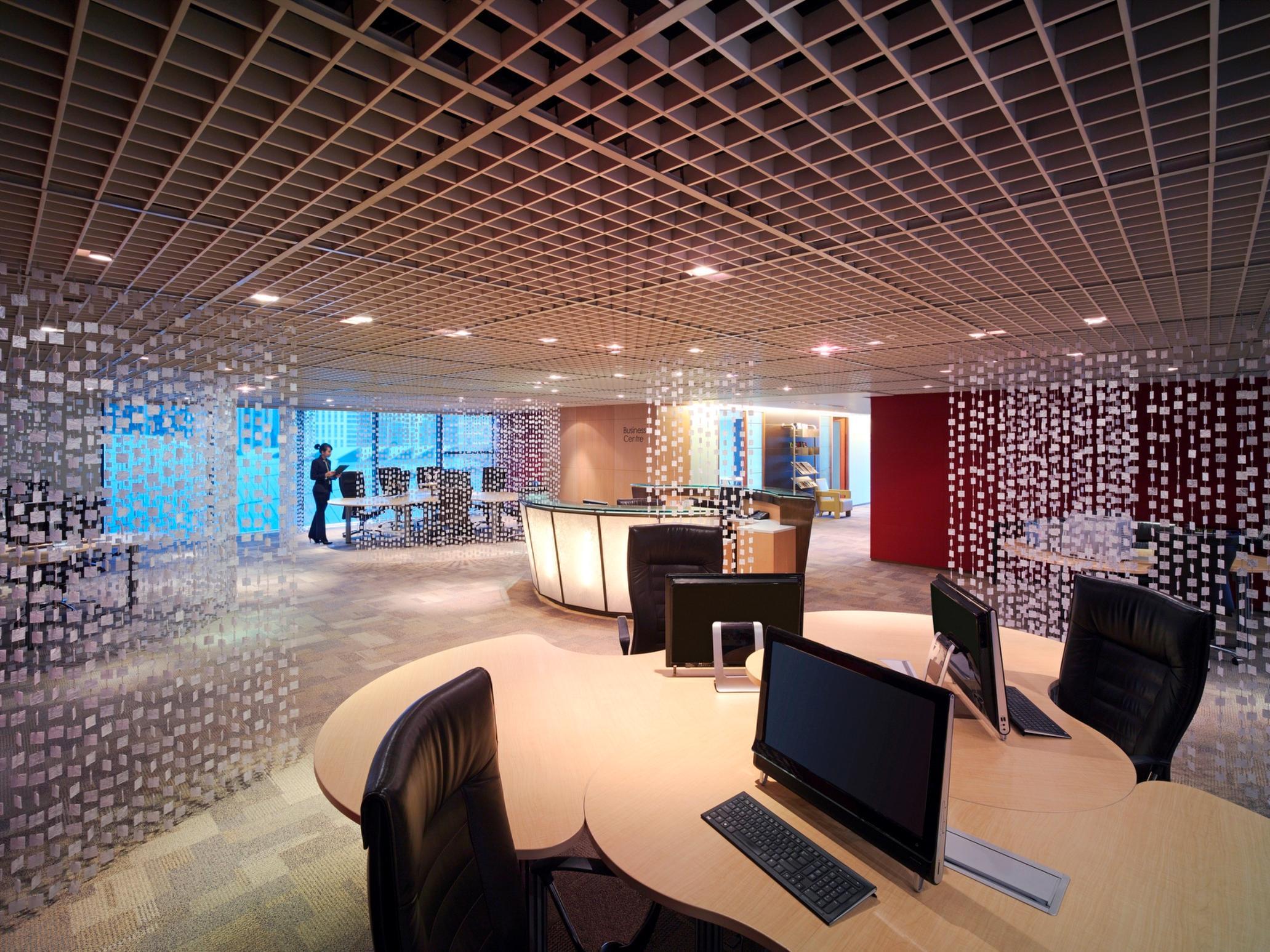 Traders Hotel, קואלה לומפור מראה חיצוני תמונה The photo shows a modern office interior. It features a spacious layout with several workstations equipped with computers and ergonomic chairs. The design includes a unique ceiling with a grid pattern that gives a contemporary feel. There are transpa