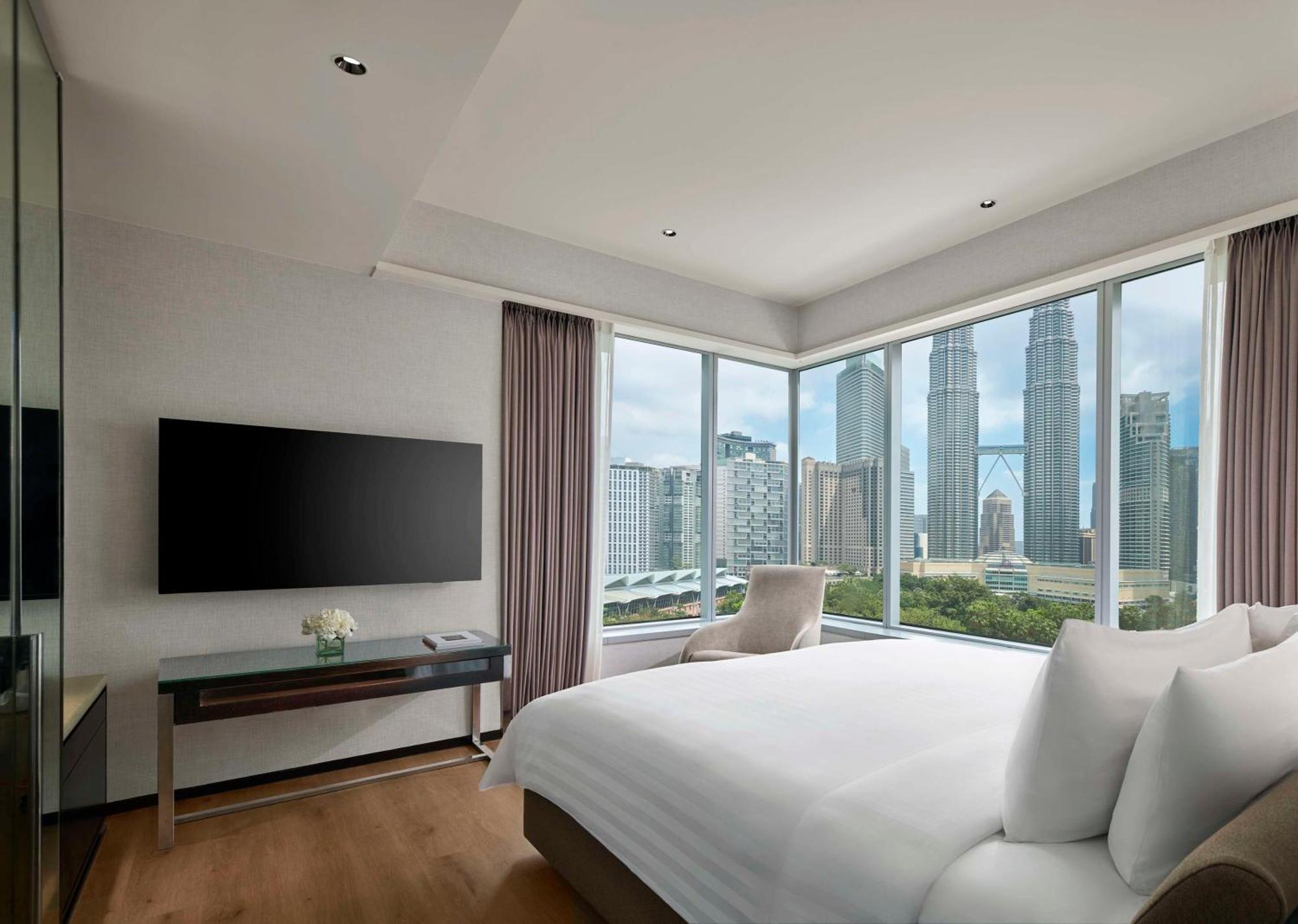 Traders Hotel, קואלה לומפור מראה חיצוני תמונה The photo depicts a modern hotel room with a sleek and contemporary design. It features a large bed with white linens and several decorative pillows. A flat-screen television is mounted on the wall opposite the bed, and a stylish media console is bel